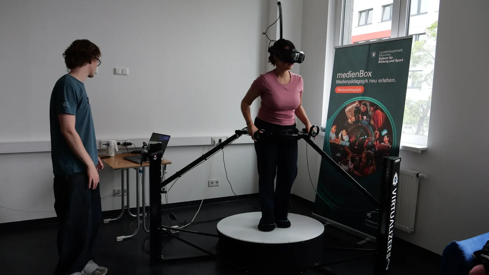 Frau mit VR-Brille auf einer Virtualizer-Laufplattform, betreut von einem Mitarbeiter