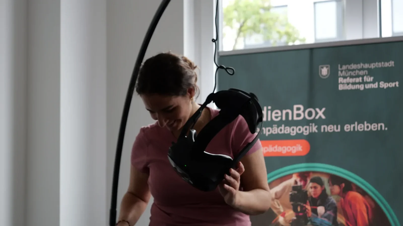 Frau nimmt lachend eine VR-Brille ab, im Hintergrund das medienBox-Rollup