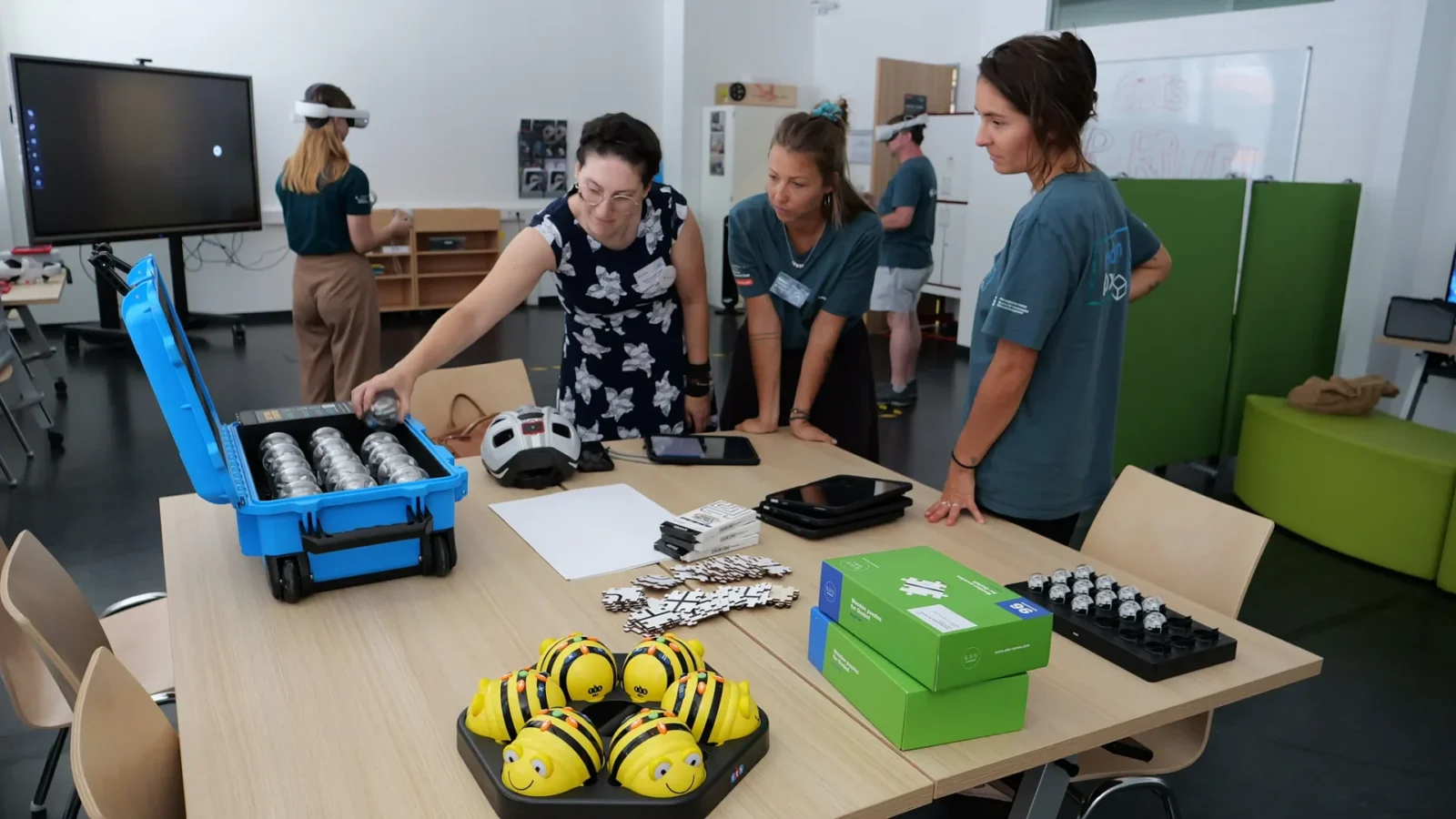 Workshop mit Bee-Bot-Robotern, Ozobots und Tablets im Makerspace, im Hintergrund VR-Brillen