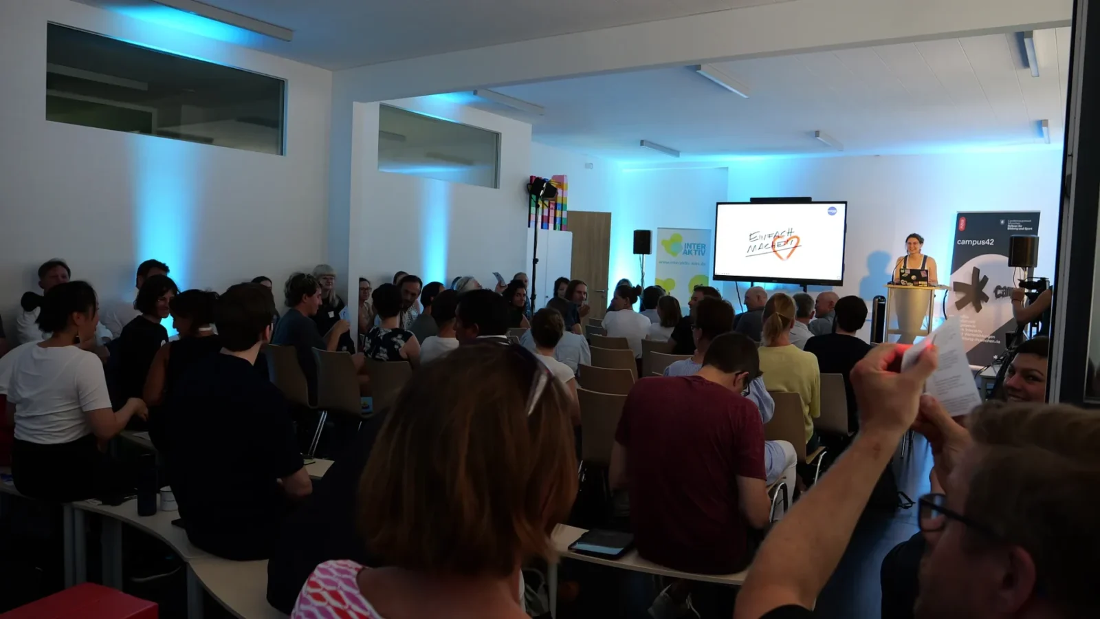 Voll besetzter Seminarraum beim Barcamp, Blick zur Referentin und zur Präsentation „Einfach machen"